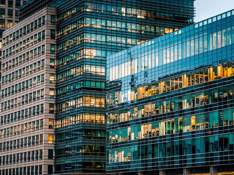 The image shows the exterior of a modern office building, specifically identified as the Schneider Electric Building in Singapore, which is part of the CapitaLand portfolio. 